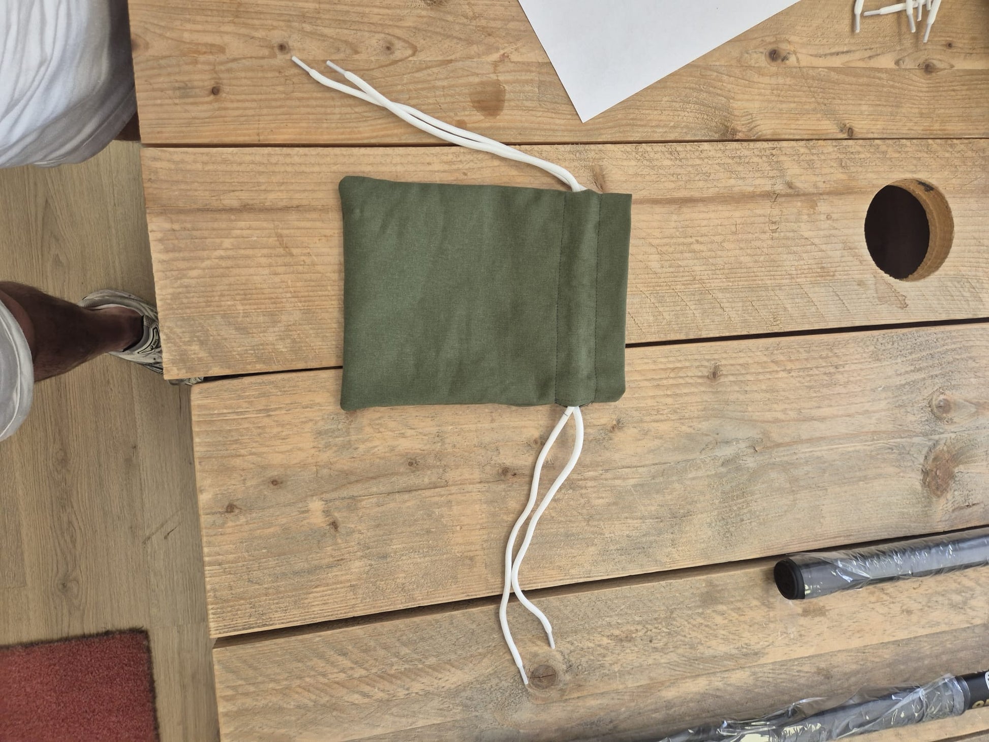 Grijs upcycled opbergzakje van reststof met witte trekkoorden, open weergegeven