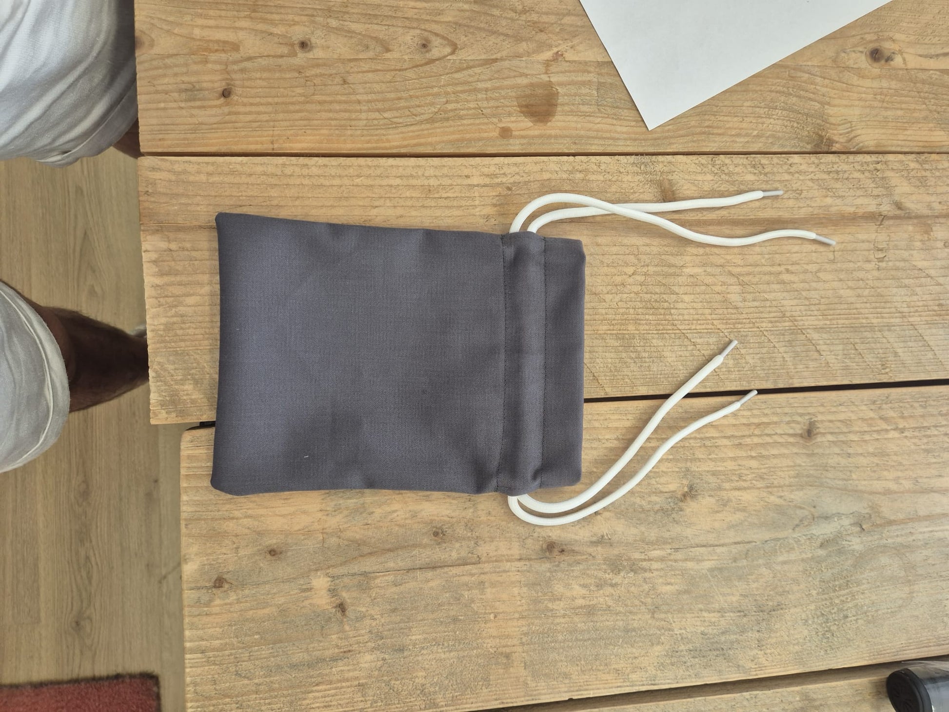 Groen upcycled opbergzakje van reststof met witte trekkoorden, open weergegeven