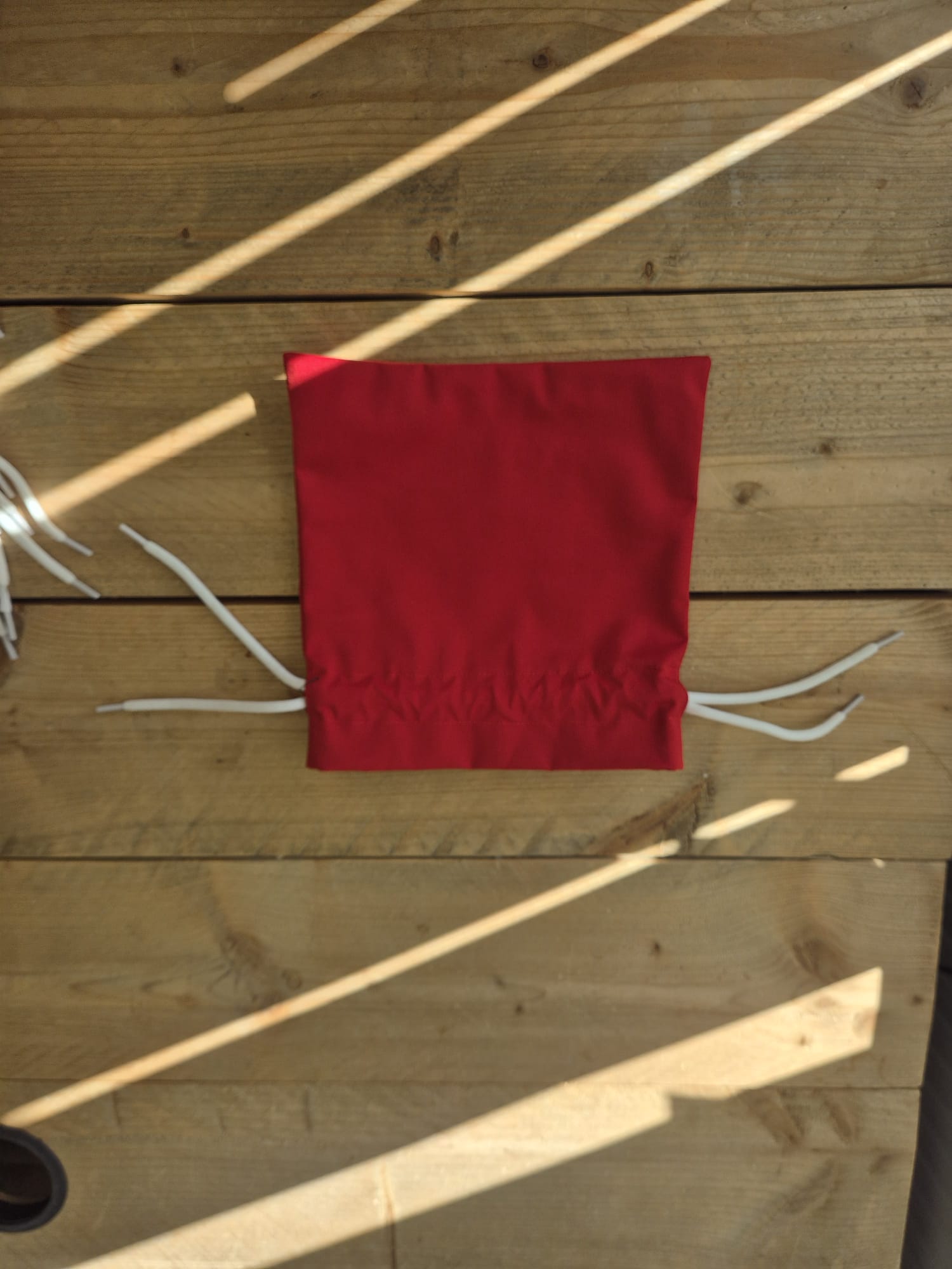 Rood upcycled opbergzakje van reststof met witte trekkoorden, open weergegeven
