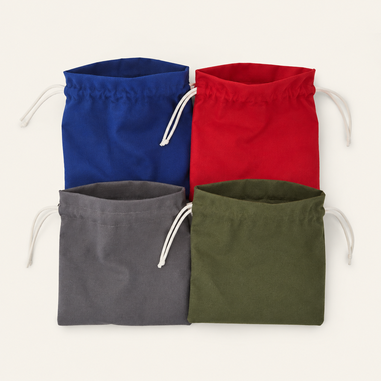 Vier upcycled opbergzakjes van reststof in blauw, rood, grijs en groen